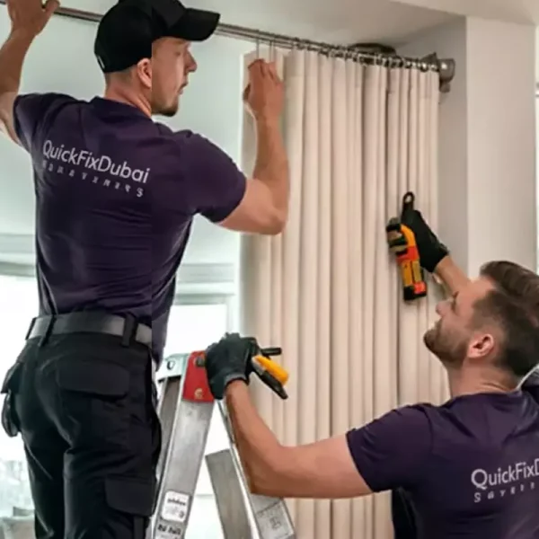 Two skilled handyman professionals collaborating on curtain installation in a luxurious living room, one on a ladder and the other supporting with tools.